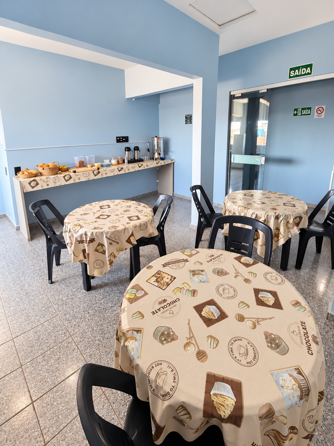 Área de café da manhã com mesas e buffet no Hotel São João